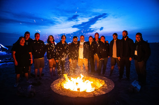 Group of men standing around campfire
