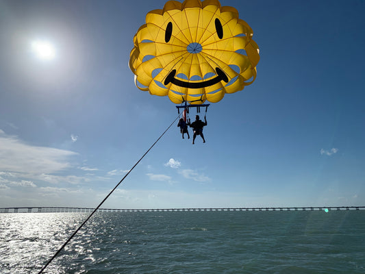 man and girl parasailing 